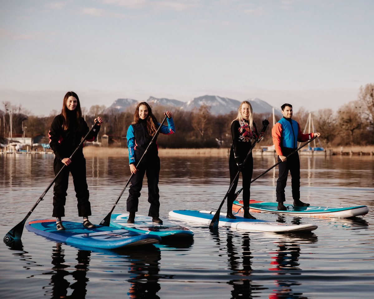 un groupe de personnes sur des planches de stand up paddle sur un lac